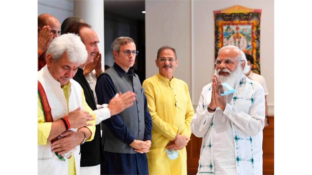 This photograph provided by the Prime Minister's Office shows Indian Prime Minister Narendra Modi, right, greeting members of various political parties before the start of their meeting in New Delhi, June 24, 2021.