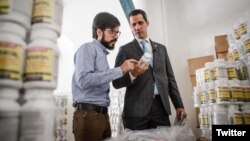 "Presiden sementara" Venezuela, Juan Guaido (kanan) dan anggota DPR Miguel Pizarro memeriksa bantuan kemanusiaan yang baru tiba di Caracas, Venezuela. Senin, 11 Februari 2019.