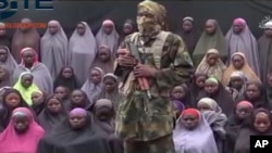 Tentara Boko Haram berdiri di depan sebagian dari 276 remaja putri yang diculik dari Chibok, dalam video yang diunggah pada tanggal 14 Agustus 2016 (Foto: dok/Militan-Site Institute via AP).