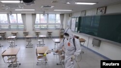 A quarantine worker sprays disinfectant at a high school, following the coronavirus disease outbreak, in Seoul, South Korea, May 11, 2020.