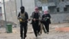 Gunmen patrol during clashes with Iraqi security forces in Fallujah, 40 miles (65 kilometers) west of Baghdad, Iraq, Jan. 5, 2014. 