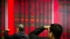 In this Oct. 31, 2018, photo, Chinese investors monitor stock prices at a brokerage house in Beijing. China's government is trying to dispel stock market gloom and talk prices back up with promises of tax cuts and a media campaign led by its economic czar. 
