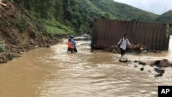 Warga berjalan melewati banjir yang menggenangi provinsi utara Son La, Vietnam, Kamis, 12 Oktober 2017.