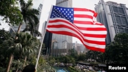 一名男子手持美國國旗在港島參加反對香港警察對反送中示威者過度使用暴力的遊行。 （2019年7月28日）