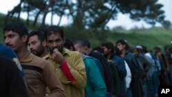 FILE - Migrants queue to receive food in a camp set up by volunteers near the port of Mytilini, in the Greek island of Lesbos, April 7, 2016. Pope Francis to visit the island on April 16, 2016.