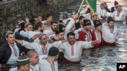 Bulgarians sing and chain dance in the icy waters of the Tundzha river during Epiphany, in Kalofer, Bulgaria, Jan. 6, 2020. 