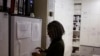 FILE - Pharmacist Mary Chindanyika looks at documents on a fridge containing a trial vaccine against HIV on the outskirts of Cape Town, South Africa, Nov. 30, 2016. 