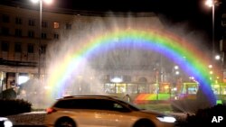 Cars drive past a light-and-water rainbow installation on the night before a gay pride parade, in downtown Warsaw, Poland, June 8, 2018. A conservative turn in Poland has made the fight for gay rights all the more difficult.