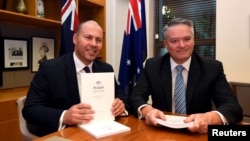 Treasurer Josh Frydenberg poses for a photograph with Minister for Finance Mathias Cormann with the 2019 Budget papers ahead of Budget 2019 at Parliament House in Canberra, Australia, April 2, 2019.