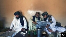 巴基斯坦人在茶館裡閱讀當地報紙關於基地組織資深領導人毛利塔尼被捕的報導