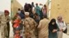 Iraqi soldiers help civilians, who fled from Falluja because of Islamic State violence, during a dust storm on the outskirts of Fallujah, Iraq, June 18, 2016