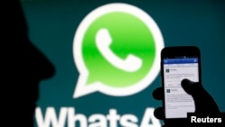 A Whatsapp App logo is seen behind a Samsung Galaxy S4 phone that is logged on to Facebook in the central Bosnian town of Zenica, February 20, 2014. Facebook Inc will buy fast-growing mobile-messaging startup WhatsApp for $19 billion in cash and stock in 
