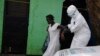 A health worker brings a woman suspected of having contracted the Ebola virus to an ambulance in Monrovia, Liberia, Sept. 15, 2014.