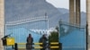 Taliban fighters stand guard at the main gate of Laghman University in Mihtarlam, Laghman province, Feb. 2, 2022. 