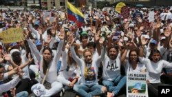 Lilian Tintori (nomor empat dari kanan), istri dari pemimpin oposisi Leopoldo Lopez, memimpin aksi duduk memblokie jalan bebas hambatan Franciso Fajardo sesusai pawai aksi unjuk rasa perempuan melawan represi diblokir pihak berwenang saat hendak menuju Kementerian Dalam Negeri di Caracas, Venezuela, 6 Mei 2017. (AP Photo/Fernando Llano)