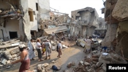 FILE - People gather at the site of a Saudi-led air strike in the Red Sea port city of Hodeidah, Yemen, Sept. 22, 2016. 