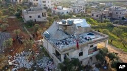 People inspect a destroyed house following a U.S. military operation in Atmeh, Syria, Feb. 3, 2022. Islamic State leader Amir Muhammad Sa'id Abdal-Rahman al-Mawla was killed in the raid.