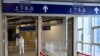 Seorang pria berjaga di pintu keluar stasiun kereta Taizicheng, di Zhangjakou pada 29 Januari 2022. Beijing, Rabu (4/5), menutup sekitar 10% stasiun di sistem kereta bawah tanahnya yang luas sebagai tindakan tambahan terhadap penyebaran virus corona.(Foto: AFP)