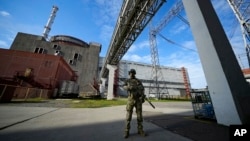 Seorang prajurit Rusia berjaga di area Pembangkit Listrik Tenaga Nuklir Zaporizhzhia di wilayah yang berada di bawah kendali militer Rusia, tenggara Ukraina, pada 1 Mei 2022. (Foto: AP)