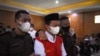 Herry Wirawan (tengah) dikawal sebelum diadili di pengadilan di Bandung, Jawa Barat pada 15 Februari 2022, di mana ia kemudian dijatuhi hukuman penjara seumur hidup atas pemerkosaan terhadap 13 siswa, semuanya di bawah umur. (Foto: AFP/Timur Matahari)