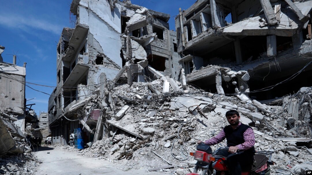 A man rides past destruction in the town of Douma, the site of a suspected chemical weapons attack, near Damascus, Syria, April 16, 2018. 