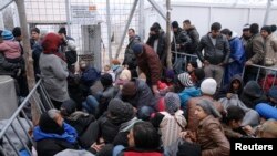 Migrants wait to cross the Greek-Macedonian border at a makeshift camp, near the village of Idomeni, Greece March 7, 2016.