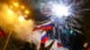 Sekelompok orang mengibarkan bendera Rusia dalam perayaan pengakuan wilayah Donestk sebagai republik independen oleh Rusia pada 21 Februari 2022. Donetsk merupakan wilayah di Ukraina timur yang dikuasai oleh kelompok separatis pro-Rusia. (Foto: AP/Alexei Alexandrov)