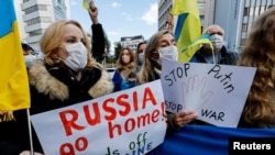 Ukrainians residing in Japan hold placards and flags during a protest rally denouncing on Russia over its actions in Ukraine, near Russian embassy in Tokyo, Japan Feb. 23, 2022.