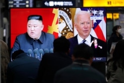 Gambar pemimpin Korea Utara Kim Jong Un dan Presiden AS Joe Biden selama siaran berita di Stasiun Kereta Api Suseo di Seoul, Korea Selatan, 26 Maret 2021. (Foto: AP)