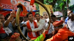 Pendukung Partai Bharatiya Janata (BJP) merayakan hasil awal yang menunjukkan partai tersebut menang dalam pemilihan di Mumbai, India, 19 Oktober 2014. 