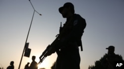 FILE - Afghan security forces stand guard after an attack on the American University of Afghanistan in Kabul, Afghanistan, Aug. 25, 2016.