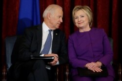 FILE - U.S. Vice President Joe Biden and former Secretary of State Hillary Clinton attend a ceremony to unveil a portrait honoring retiring Senate Minority Leader Harry Reid on Capitol Hill in Washington, Dec. 8, 2016.