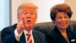Republican presidential candidate Donald Trump holds a Hispanic advisory roundtable meeting in New York, Aug. 20, 2016. At right is Jovita Carranza, former Small Business Administration Deputy Administrator.