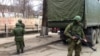 Soldiers without insignia guard buildings in the Crimean capital, a day after the Ukrainian prime minister called for Russian help, Simferopol, Ukraine, March 2, 2014. (Elizabeth Arrott/VOA).