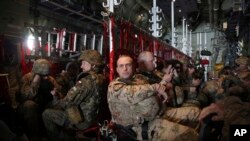 Tentara Pakta Pertahanan Atlantik Utara (NATO) menaiki pesawat Angkatan Udara AS dalam rotasi rutin dari Kandahar ke Kabul, di Afghanistan, 20 Maret 2018. (Foto: Rahmat Gul/AP Photo)
