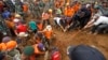 Recovery workers try to extricate the body of a victim of last week's landslide in Jemblung, Indonesia, Dec. 14, 2014