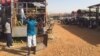 Workers offload fruit trucks from Uganda at Juba's Gumbo Market on March 10, 2015. Business owners are feeling the pressure as the strength of the South Sudanese pound weakens. (Photo: G. Joselow / VOA)