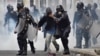 Police help a pedestrian overcome by tear gas as supporters of Salvador Nasralla, presidential candidate for the Opposition Alliance Against the Dictatorship, clash with police during a protest caused by the delayed presidential vote count, Dec. 1, 2017.