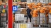 Pegawai Layanan Pos AS (USPS) berjalan di tengah kumpulan paket yang masuk ke area Pusat Pemrosesan dan distribusi Los Angeles, pada 30 November 2022. (Foto: AFP/Frederic J. Brown)