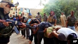 지난 6월 수니파 무장단체 이슬람국가 ISIL 병사들이 이라크 군 포로들을 총으로 위협하고 있다. (자료사진)
