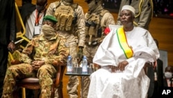 FILE - Retired Col. Maj. Bah N'Daw, right, is sworn into the office of transitional president, and Col. Assimi Goita, left, is sworn into the office of transitional vice president, at a ceremony in the capital Bamako, Mali, Sept. 25, 2020.
