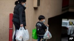 2일 미국 로스엔젤레스의 차이나타운에서 마스크를 착용한 모자의 손에 장 본 물품이 들려 있다. (자료사진) 