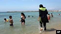 20岁的穆斯林女子尼丝莱恩·萨马利穿着传统穆斯林服装在法国南部马赛海边戏水。（2016年8月4日）