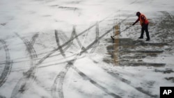 Radnik čisti sneg sa piste na aerodromu u Detroitu, u Mičigenu, 6. januara 2025.