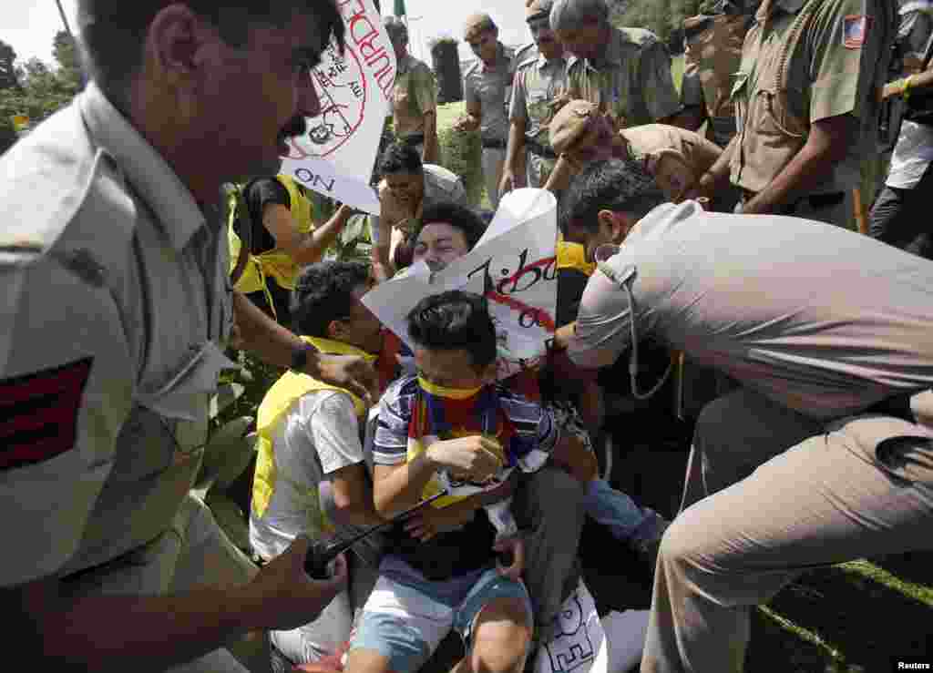 Police surround exiled Tibetans during a protest against the visit of China's President Xi Jinping near the Chinese embassy, in New Delhi, Sept. 17, 2014. 