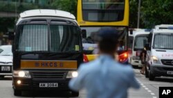 Sebuah van penjara, kiri, yang menurut seorang petugas polisi membawa Tong Ying-kit tiba di pengadilan di Hong Kong Rabu, 23 Juni 2021. Tong adalah orang pertama yang diadili berdasarkan Undang-Undang Keamanan Nasional di Hong Kong. (Foto: AP)