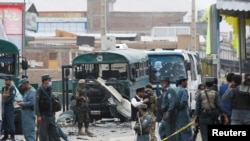 Petugas keamanan Afghanistan memeriksa kerusakan yang timbul akibat ledakan bom di lokasi dekat Kabul, Afghanistan (30/6).