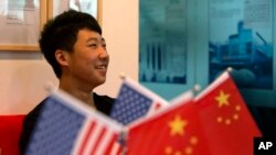 一位16岁的中国学生在北京一家教育机构里的美中两国国旗旁（2014年6月26日）