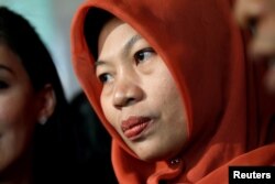 Baiq Nuril Maknun, petugas pembukuan sekolah yang dipenjara setelah mencoba melaporkan pelecehan seksual, bereaksi kepada wartawan saat tiba di kantor Kementerian Hukum dan Hak Asasi Manusia, di Jakarta, 8 Juli 2019. (Foto: Reuters)