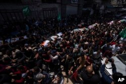 Para pelayat membawa jenazah warga Palestina yang tewas dalam serangan udara Israel, saat pemakaman mereka di Kota Gaza, Selasa, 9 Mei 2023.
